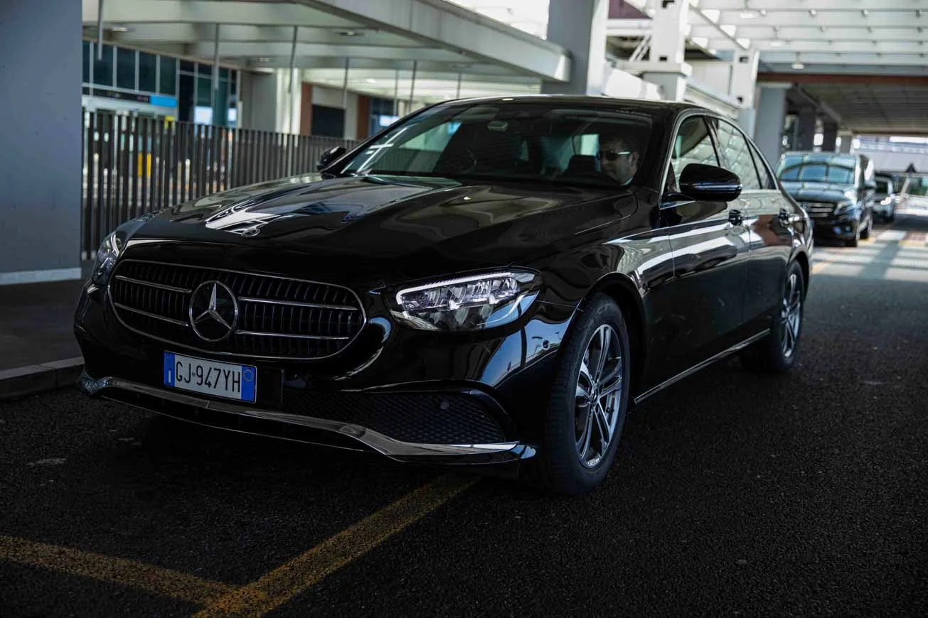 Berlina Mercedes Classe E nera, frontale, aeroporto — servizio NCC