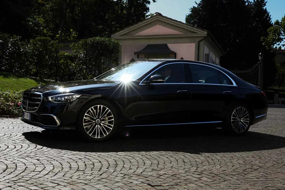 Mercedes Classe S nera in profilo, giardino di villa italiana Mercedes Classe S nera in profilo, giardino di villa italiana