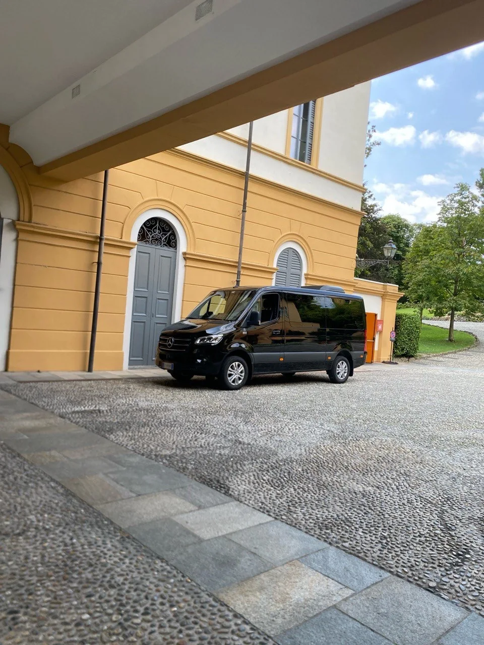 Minivan Mercedes Sprinter nero frontale, villa italiana