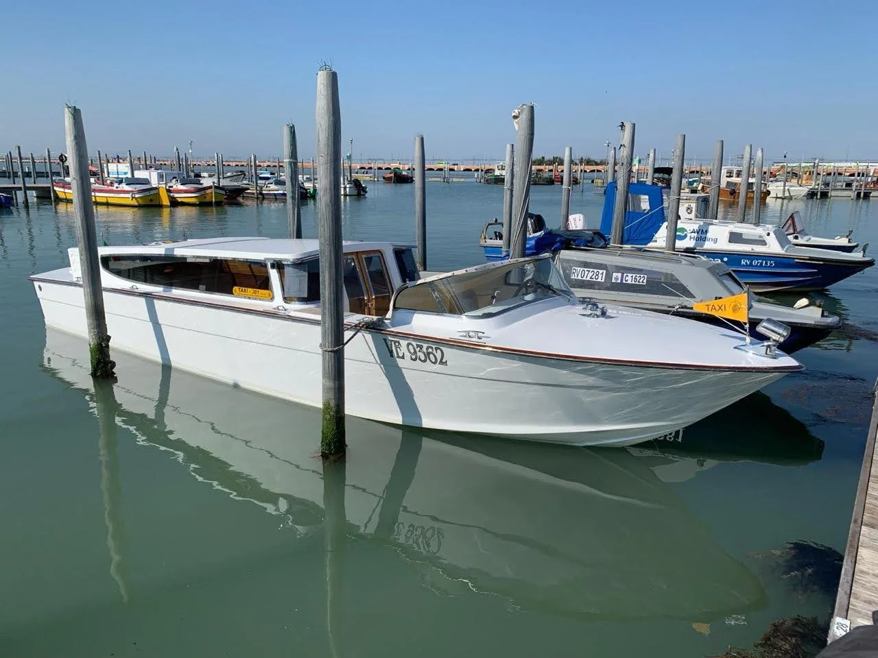 Water taxi veneziano bianco ormeggiato nel porto di Venezia Water taxi veneziano bianco ormeggiato nel porto di Venezia